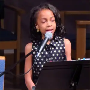 Gabby, a DenLee Music School voice student, singing at a recital