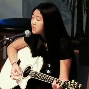 Guitar and vocal student performing at a recital